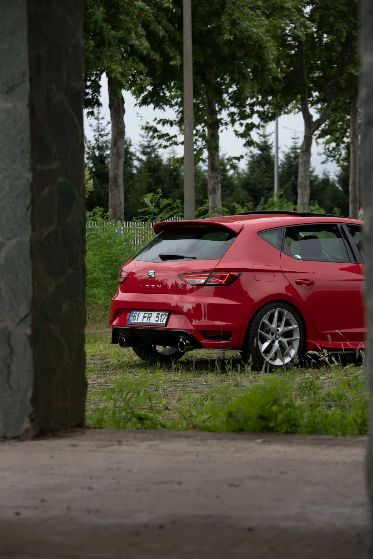 Auto rojo estacionado junto a árboles